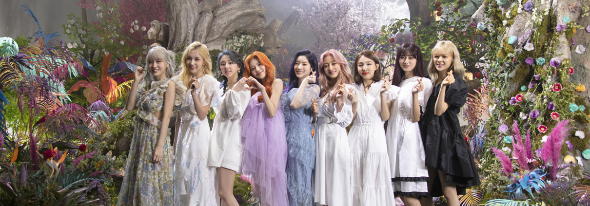 TWICE's members posing with finger hearts on the set of the music video for "More & More."